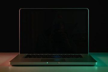 Aufkleber - Beautiful silver laptop in the color light on a table and night background.