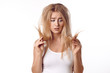 © Lars Zahner - Pretty young woman having a bad hair day standing looking dejectedly at the dry ends of her tousled long blond hair as she holds them up in her hands isolated on white