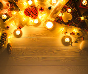 Wall Mural - Candles burning among beautiful Christmas lights and garland decorations. New Year festive background. Presents, gifts, greeting postcard for winter holidays.