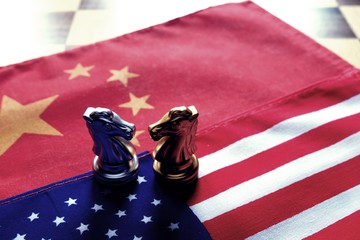 Chess game. Two knights face to face on Chinese and American national flags. Trade war and conflict between two big countries. USA and China relationship concept.