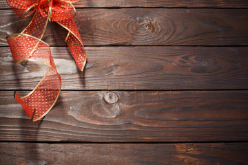 Wall Mural - red and golden bow on dark wooden background