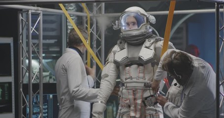scientists attaching anti-gravity bands to astronaut
