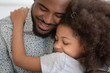 © fizkes - Loving african American dad hug little daughter