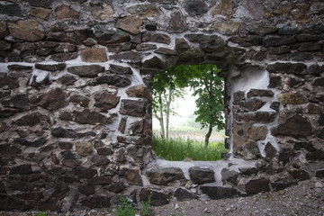 Stone House Background. Abandoned stone house with empty window frame overlooks a foggy forest. 