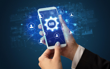 Poster - Female hand holding smartphone with IVR abbreviation, modern technology concept