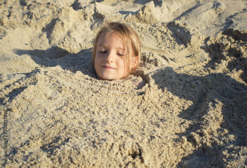 dziewczynka bawiąca się na plaży podczas letnich wakacji nad morzem  - obrazy, fototapety, plakaty 