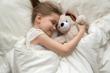 Preschooler Girl Hug Teddy Sleeping Peacefully In Cozy Bed