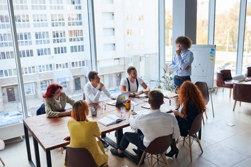 creative and enthusiastic business group sitting in office together working as team, wearing formal wear. Caucasian business people