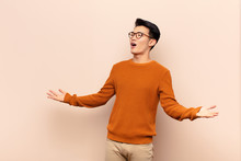 Young Chinese Man Performing Opera Or Singing At A Concert Or Show, Feeling Romantic, Artistic And Passionate Against Flat Color Wall