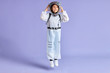 Portrait of child boy in protective white suit while jumping up isolated over purple background
