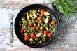 Selective focus. Frying pan with baked Brussels sprouts with cherry tomatoes, olives and thyme. Vegan food. Healthly food.
