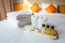 Set Of Hotel Amenities (such As Towels, Shampoo, Soap Etc) On The Bed. Hotel Amenities Is Something Of A Premium Nature Provided In Addition To The Room When Renting A Room. 