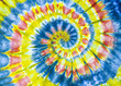 A bright yellow, red, and blue tye dye tunnel Fibonacci spiral pattern on cotton.