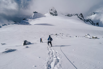 Wall Mural - Climbers walking on a glacier using rope and ice axe. Alpinist in high alpine mountain landscape, walking in snow. Adventure outdoor activity.