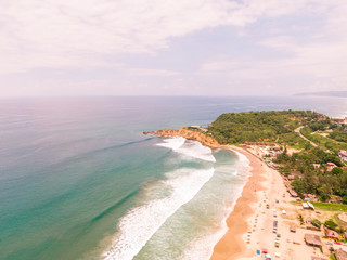 Aerial Coastline cliffs. Beach ocean drone view. Dramatic aerial DRONE view of Montanita beach town, and 'The Point' cliffs at sunrise. View of the ocean, sand, coastline, waves and rocks. Ecuador.