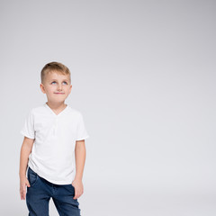 Wall Mural - cute little boy thinking about something - copy space over white background