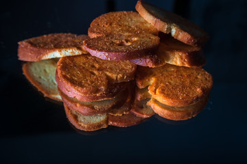 Wall Mural - Mini bruschettes with spices with reflection on shiny black background