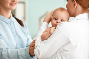 Woman with little baby visiting pediatrician in clinic