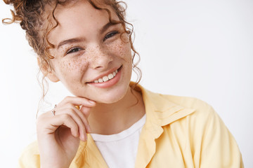 Headshot carefree delighted lucky young 20s girl redhead freckles cheeks touching face gently smiling grinning eyes, standing satisfied delighted hanging around friends, white background