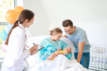 Wall Mural - Young family with newborn baby and gynecologist in maternity hospital