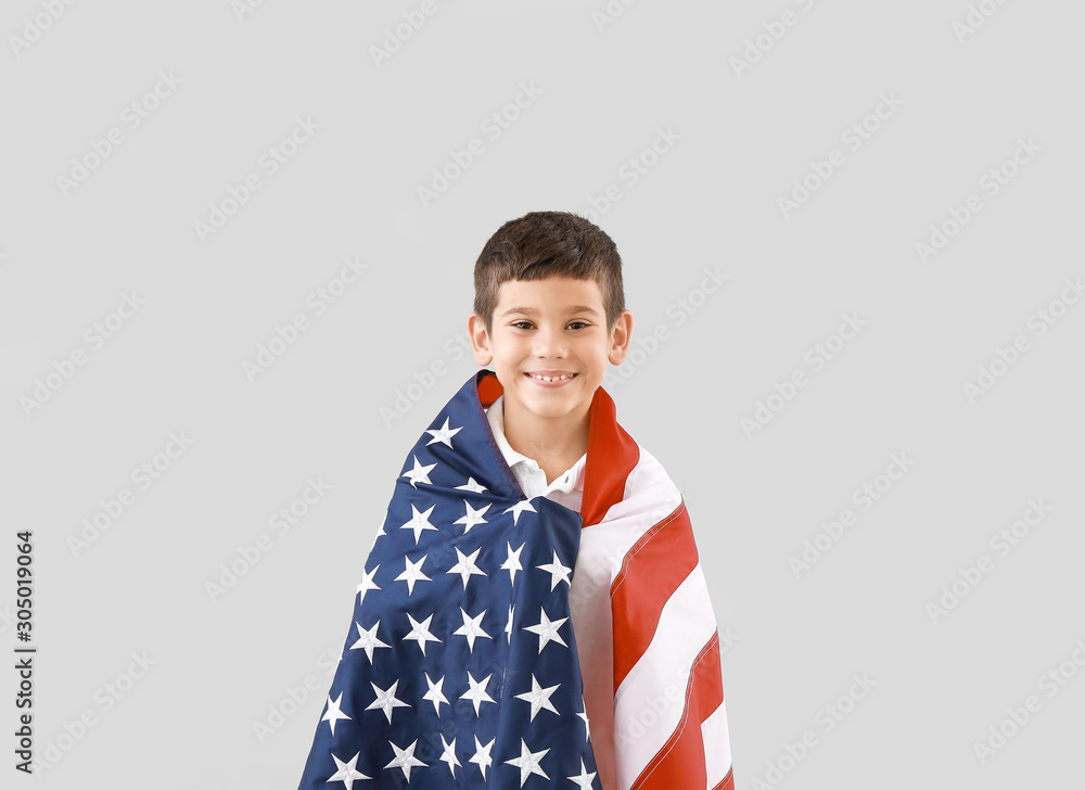 Little boy with USA flag on light background. Memorial Day celebration