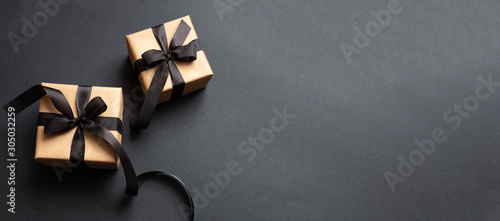 Fotomural Gifts with black ribbon against black background, Black Friday concept