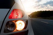 Close Up Tail Lights Of White Car On Asphalt Road With Sunlight Shining In The Shadow Of Nature.