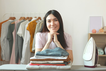 young housewife ironing clothes in the interior of the room.