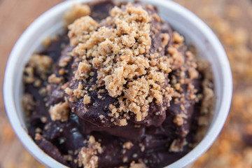 Canvas Print - Acai in cup with peanut candy on wooden background with granola