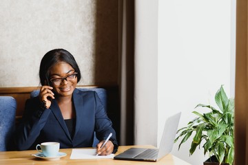 Pensive black businesswoman using tablet computer in coffee shop