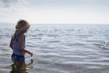 Young Girl In The Water Off A Beach On The Coast Of Scotland.