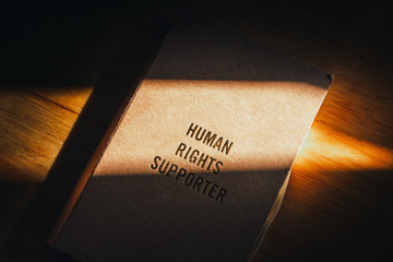 Wall Mural - human rights concept. human rights text on cover note book with light of sun feel hopeful. 