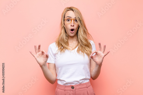 young pretty blonde woman feeling shocked, amazed and surprised, showing approva Tableau sur Toile