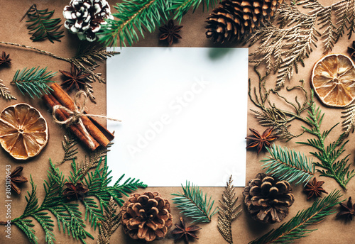 Natural Christmas decorations made of wood and pinecones without plastic. Gifts. Blank white paper sheet. Zero waste Christmas, concept flat lay.