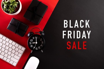 Wall Mural - Black Friday Sale text with Alarm clock, keyboard mouse, gift box on red and black background. Online Shopping concept and black Friday composition.
