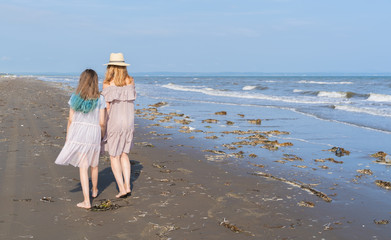 Happy mom and daughter spend time together at the seaside, family concept.