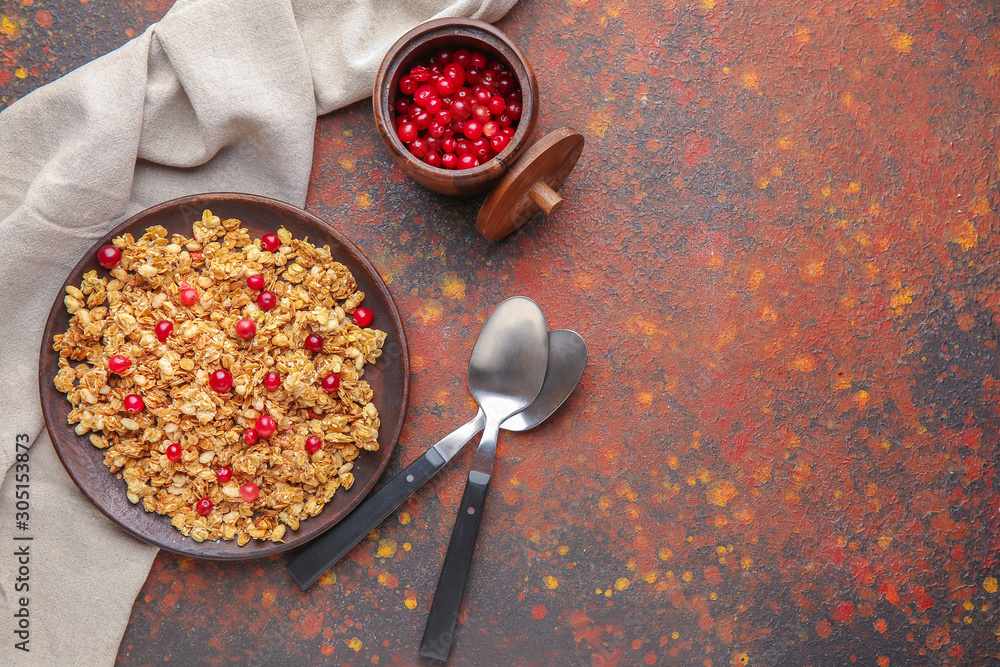 Plate with tasty granola and berries on color background