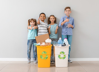 Wall Mural - Little children and containers with trash near light wall. Concept of recycling