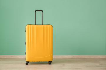 Suitcase near color wall. Travel concept