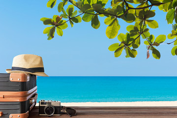 Summer travel and plan with vintage suitcase luggage and old camera in the sand beach. Travel in the holiday trips, airplane and blue sky background. Summer and Travel Concept