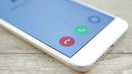 phone with incoming call on the screen over a table