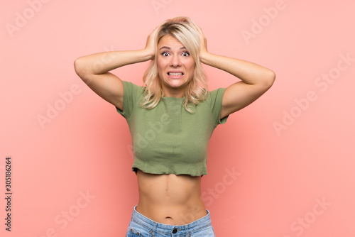 Cuadros en Lienzo Young blonde woman over isolated pink background frustrated and takes hands on h