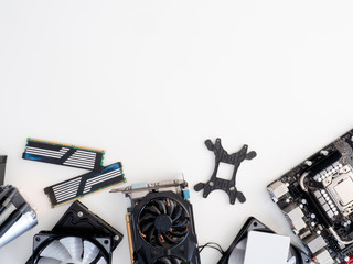 top view of computer parts with harddisk, solid state drive, ram, CPU, graphics card, liquid cooling and motherboard on white table background.