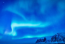 Vivid Northern Lights During Polar Night On Lofoten Islands In Norway. Epic Scene Of Dancing Aurora Borealis In The Night Sky Over Jagged Mountain Ridge And Arctic Ocean On Island Senja, Polar Circle.