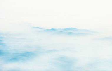 Aerial view of distant mountains layers range in morning mist. Meditation and zen landscape.