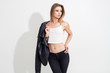 © makedonski2015 - A girl in a leather jacket and black pants posing on a white background. Fashion shooting
