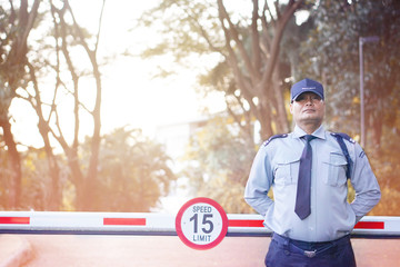 Asian Male Security Guard make saluting entry entrance the village on a blurry background. Security guard opening The entrance to the village door. Speed 15 limit in area,copy space.