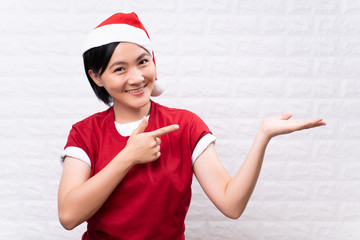 Happy woman wear santa hat present the copy space