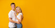 © Prostock-studio - Romantic millennial guy and girl cuddling over yellow background