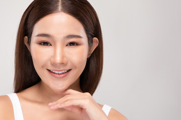 Beautiful Young Asian Woman Looking While Touching Chin feeling so happy and cheerful with healthy Clean and Fresh skin,isolated on gray background,Beauty Cosmetics Concept